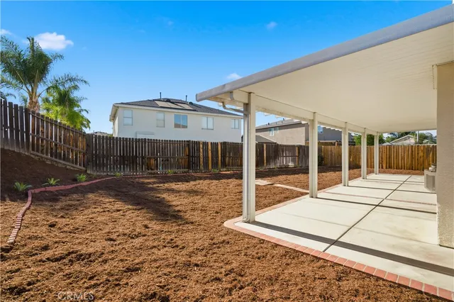 a view of a house with backyard and a patio