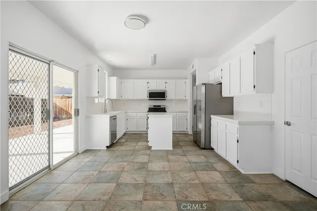 a kitchen with white cabinets and appliances