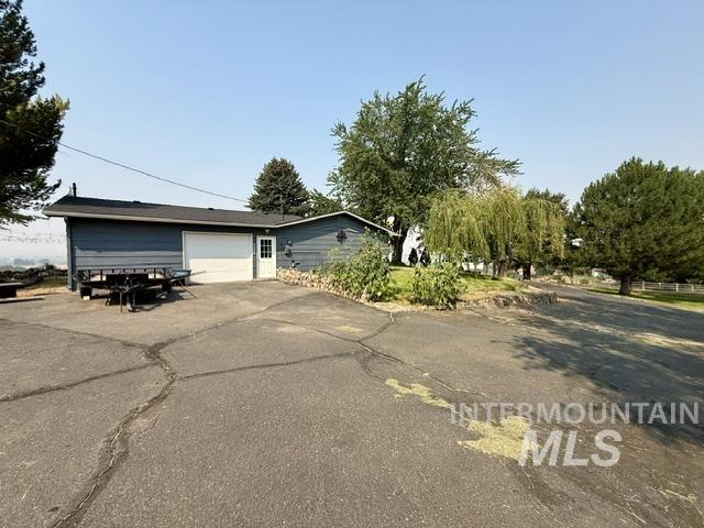 1549 Cove Road Weiser, ID 83672 - Photo 26 of 38 Exterior featuring horizontal siding, a single-car garage, a separate entry door, and a paved driveway