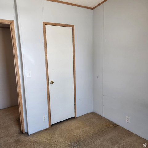 3760 Gold Ridge Drive, Unit 82 Magna, UT 84044 - Photo 27 of 29 Interior room with light gray wall paneling, white doors with brass hardware, and wood-trim accents