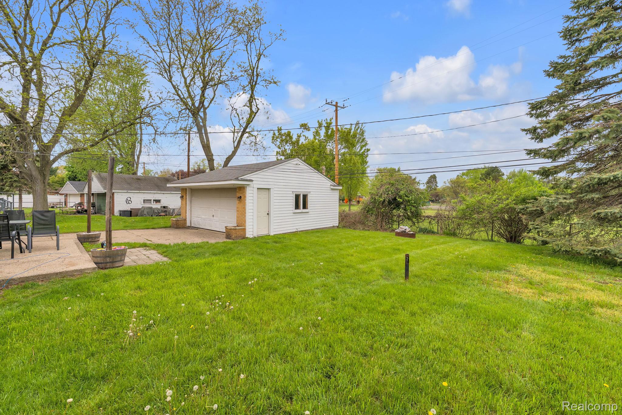 37022 Pinewood Road Wayne, MI 48184 - Photo 30 of 30 View of yard featuring an outdoor structure, a detached garage, and a patio