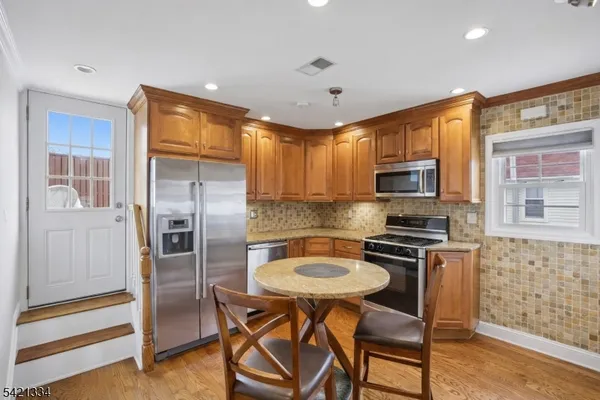 a kitchen with stainless steel appliances a stove a sink a microwave a refrigerator and cabinets