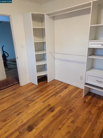 a view of walk in closet with empty racks
