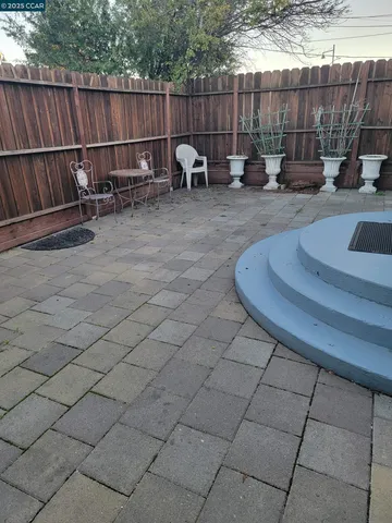 a view of a backyard with a chairs and iron fence