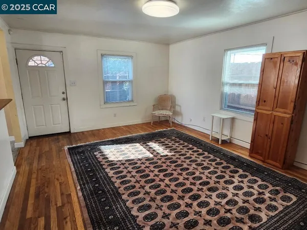 a view of a room with wooden floor and cabinets