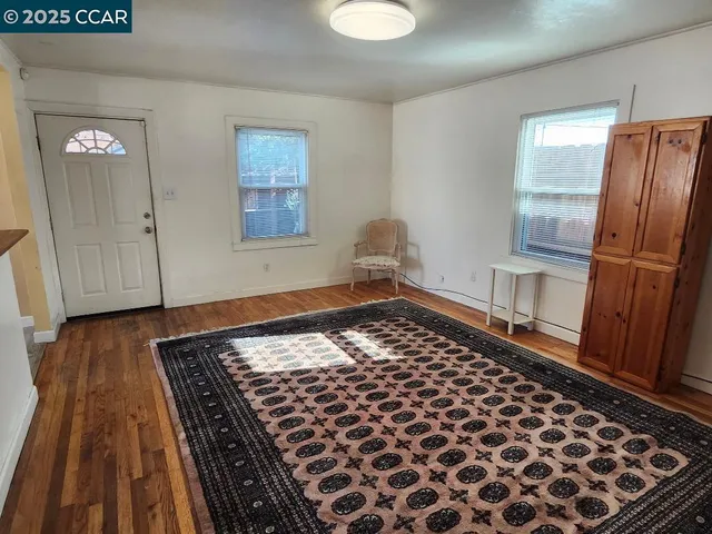 a view of a room with wooden floor and cabinets