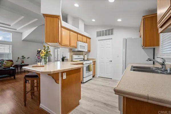 a kitchen with stainless steel appliances granite countertop a sink a stove and a refrigerator