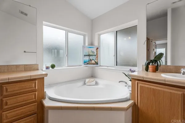 a bathroom with a granite countertop sink a toilet a mirror and vanity