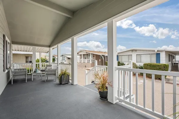 a view of a porch with furniture and floor to ceiling window