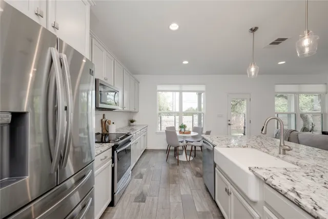 a kitchen with counter top space a sink appliances and cabinets