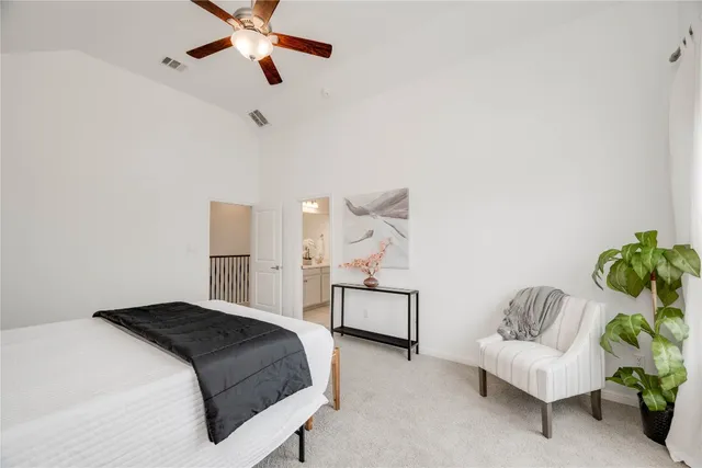 a bedroom with a bed couch and a ceiling fan