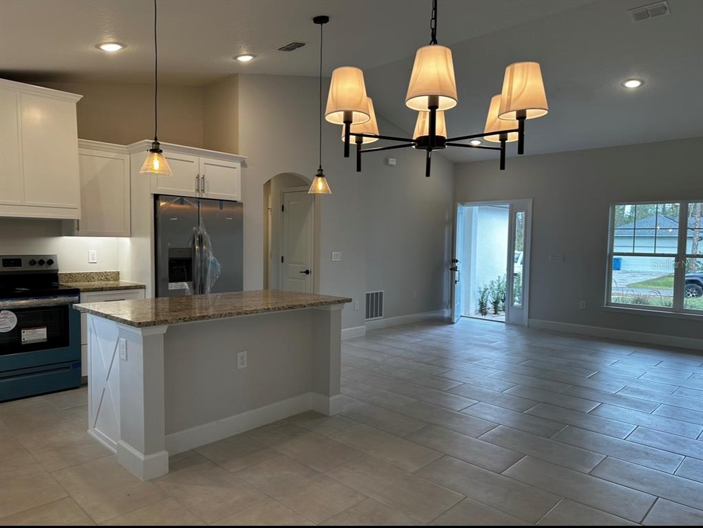 1450 5th Avenue DeLand, FL 32724 - Photo 15 of 16 a kitchen with stainless steel appliances granite countertop a sink a stove and a wooden floor