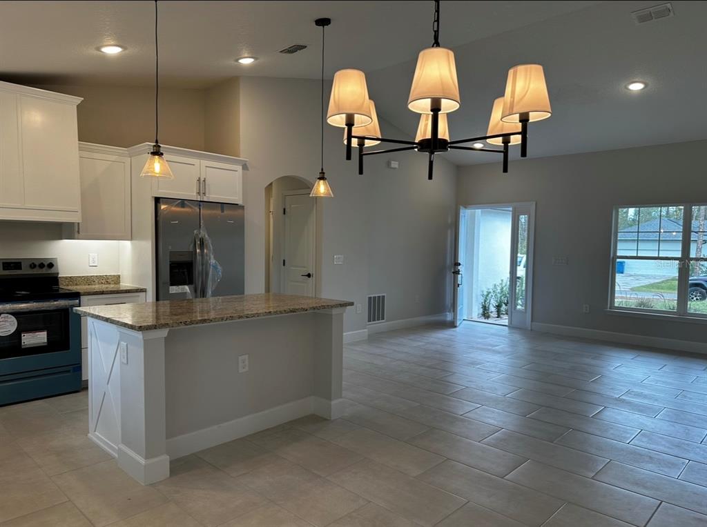 1450 5th Avenue DeLand, FL 32724 - Photo 10 of 16 a kitchen with stainless steel appliances granite countertop a sink a stove and a wooden floors