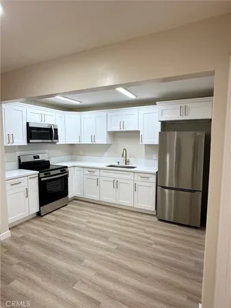 a kitchen with granite countertop a refrigerator stove top oven and sink