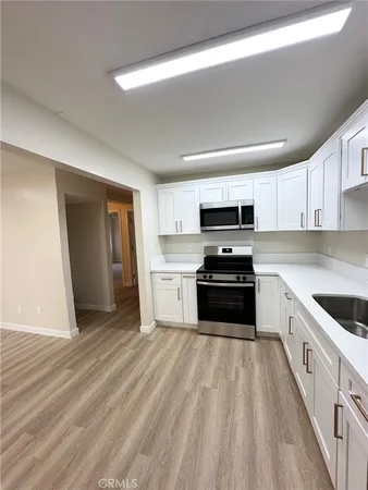 a kitchen with granite countertop a stove top oven and cabinets