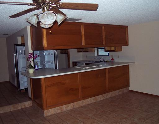 4925 Valley Stream Drive Corpus Christi, TX 78413 - Photo 5 of 10 a kitchen with stainless steel appliances granite countertop a sink wooden cabinets and a granite counter top