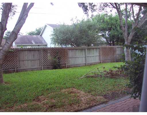 4925 Valley Stream Drive Corpus Christi, TX 78413 - Photo 9 of 10 a view of a backyard with a large tree and wooden fence