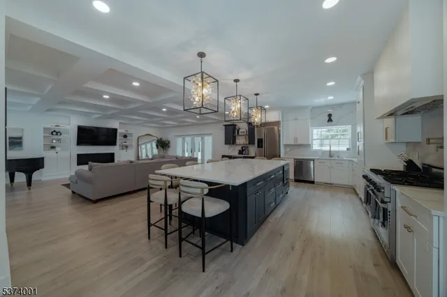 a kitchen with stainless steel appliances a sink stove and wooden floor