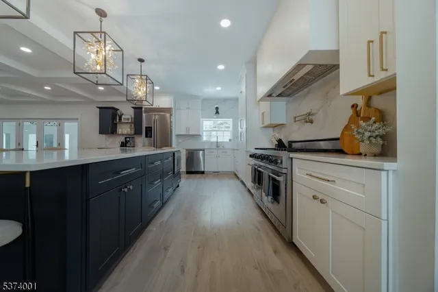 a kitchen with stainless steel appliances granite countertop a sink a stove and a refrigerator