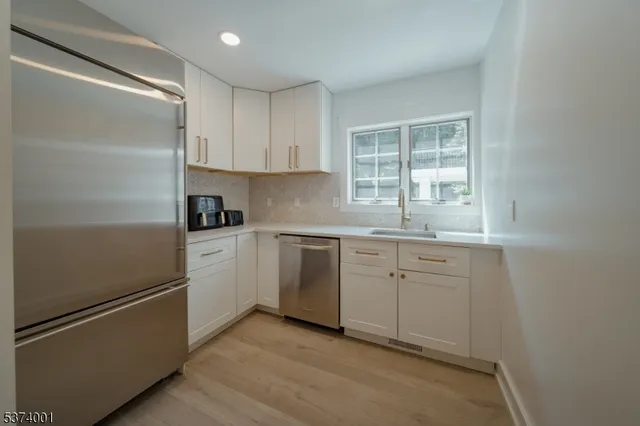 a kitchen with white cabinets and white appliances