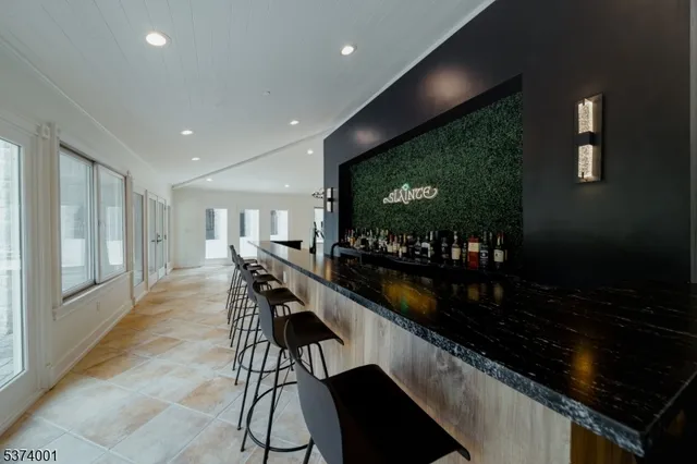 a dining hall with stainless steel appliances granite countertop a barbecue grill and couches chair with garden view