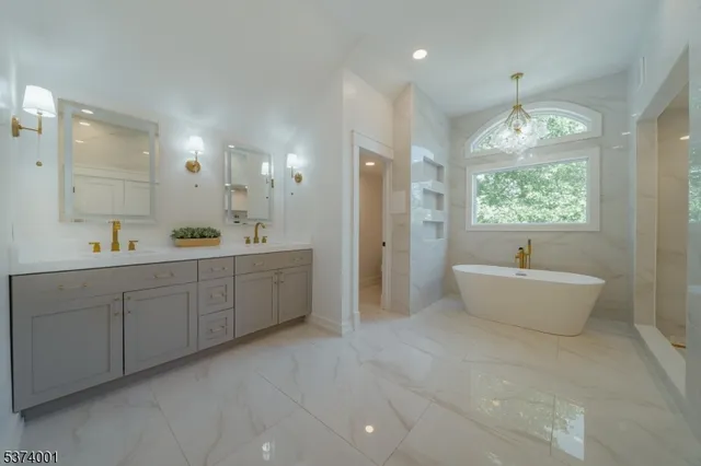 a spacious bathroom with a double vanity sink a large mirror and a bathtub
