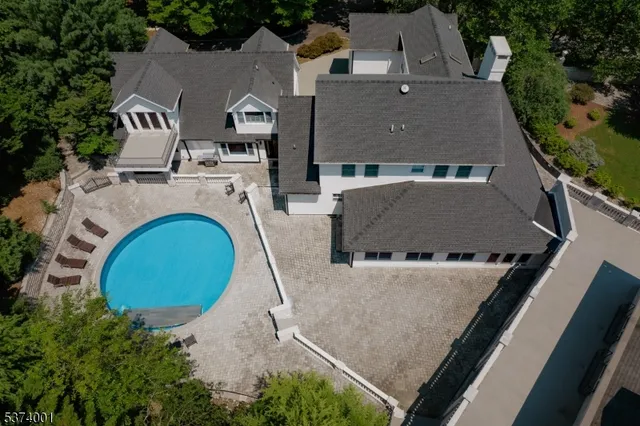 an aerial view of a house with swimming pool and big yard