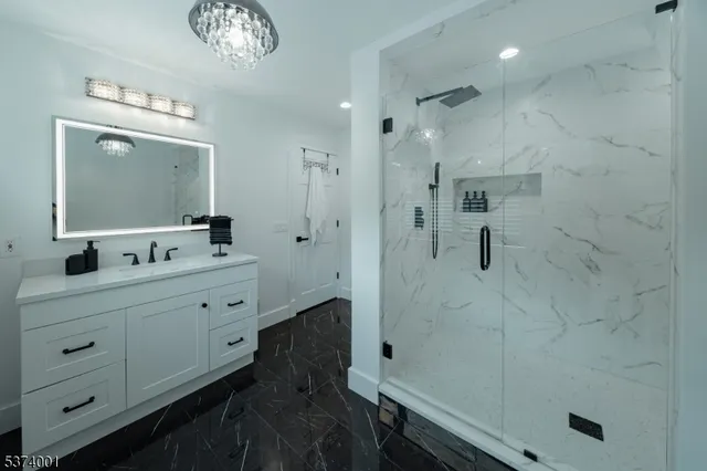 a bathroom with a double vanity sink a toilet a mirror and shower