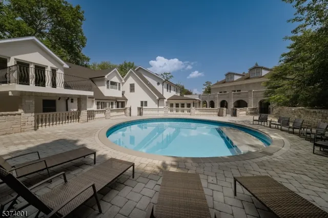 a view of a white house with a swimming pool and sitting area