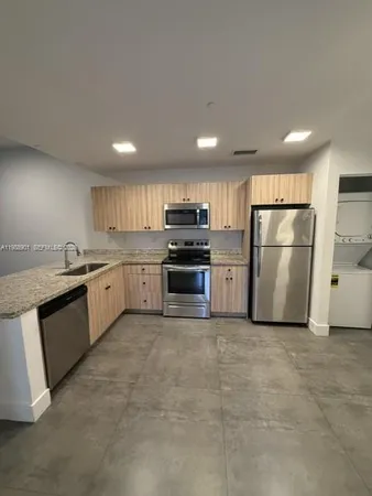 a kitchen with stainless steel appliances granite countertop a refrigerator sink and stove