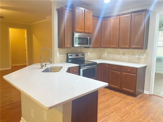 a kitchen with a sink a stove and cabinets