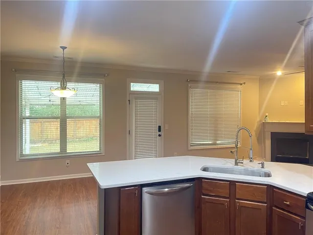 a kitchen with a sink a window and wooden floor
