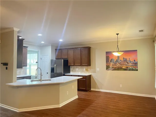a kitchen with kitchen island a sink stainless steel appliances and cabinets