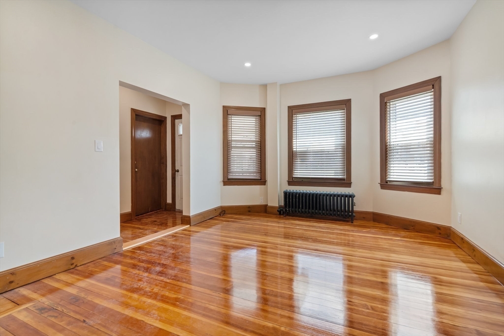 62 Vernal Street, Unit 3 Everett, MA 02149 - Photo 12 of 26 a view of an empty room with wooden floor and windows