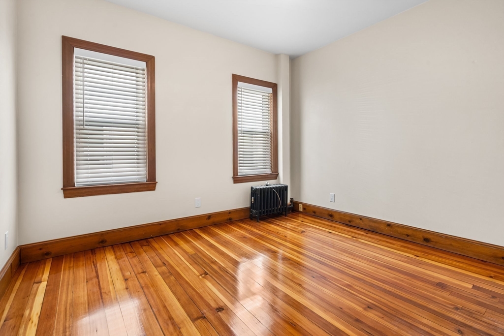 62 Vernal Street, Unit 3 Everett, MA 02149 - Photo 5 of 26 a view of an empty room with wooden floor and a window