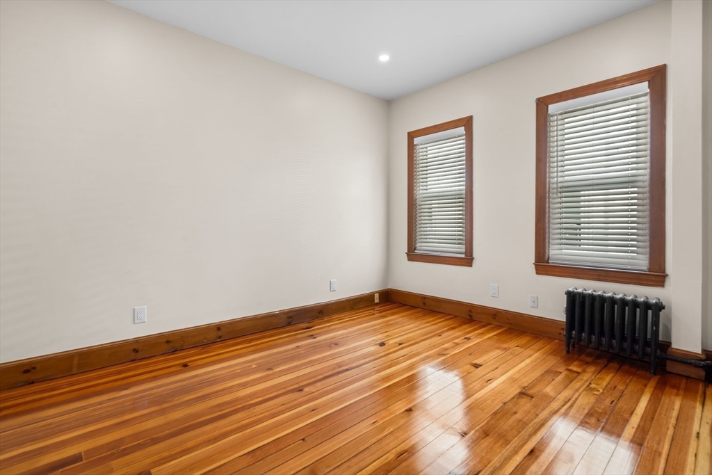 62 Vernal Street, Unit 3 Everett, MA 02149 - Photo 9 of 26 a view of an empty room with wooden floor and a window