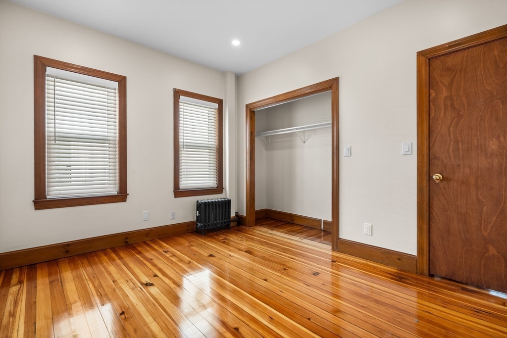 62 Vernal Street, Unit 3 Everett, MA 02149 - Photo 10 of 26 a view of an empty room with wooden floor and a window