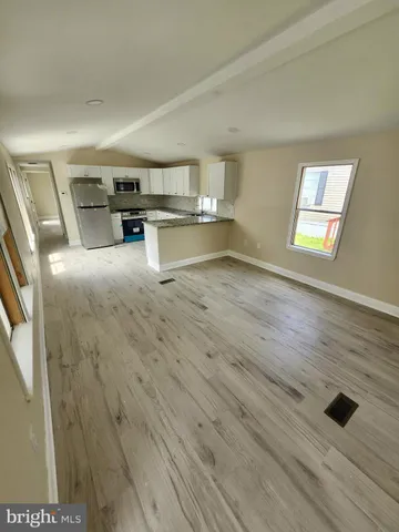 a large kitchen with cabinets wooden floor and stainless steel appliances