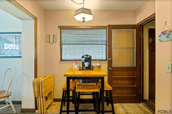 a view of a dining room with furniture and a chandelier