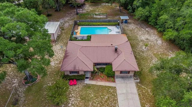 an aerial view of house with yard swimming pool and outdoor seating