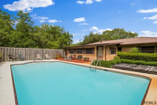 a backyard of a house with table and chairs