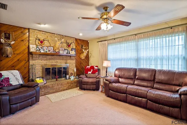 a living room with furniture kitchen view and a fireplace