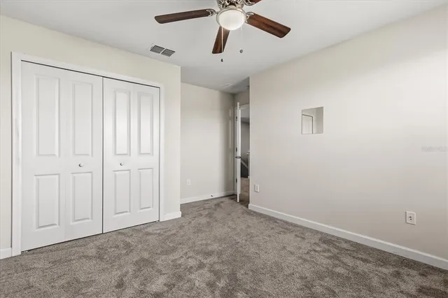 an empty room with a window and a fan