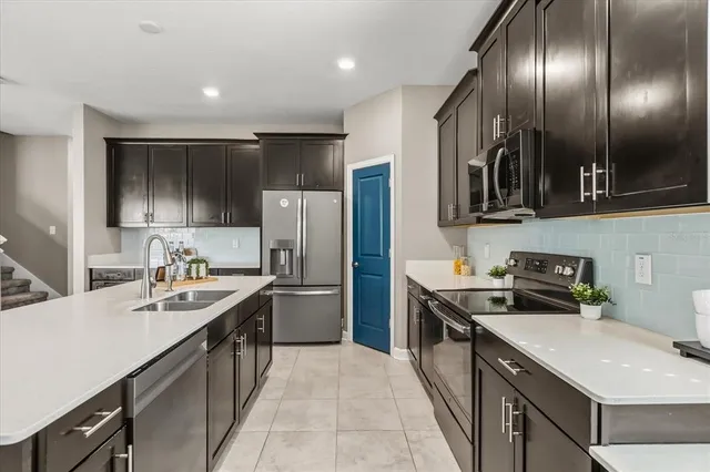 a kitchen with kitchen island granite countertop stainless steel appliances a sink stove and refrigerator