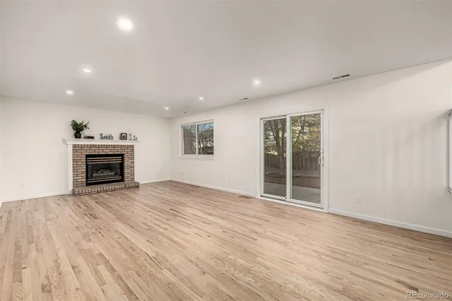 a view of a livingroom with wooden floor and staircase