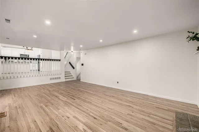 a kitchen with granite countertop a sink stainless steel appliances white cabinets and a window
