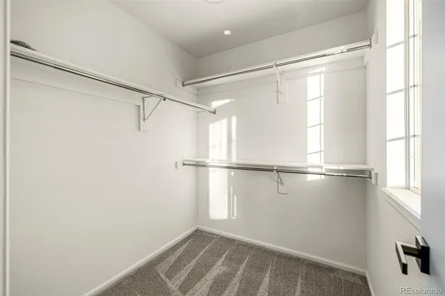 an empty room with a ceiling fan and window