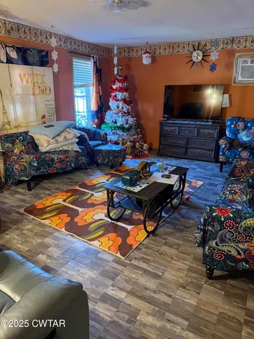 a living room with furniture a flat screen tv and a floor to ceiling window