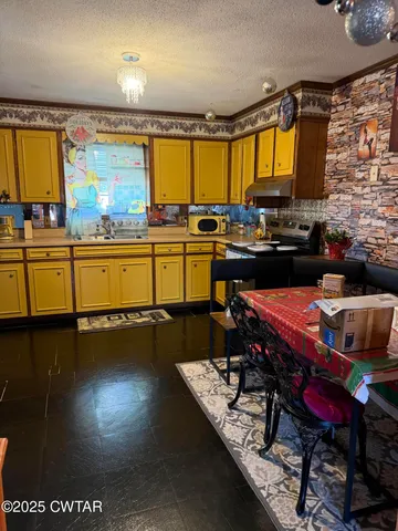 a kitchen with a sink a stove and black chairs