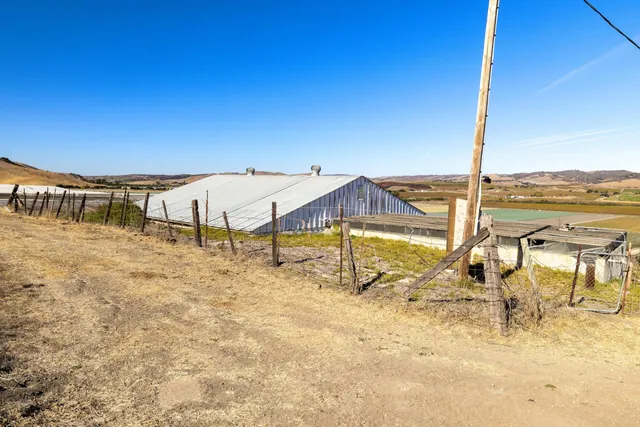 a view of a terrace with a barbeque and wooden fence